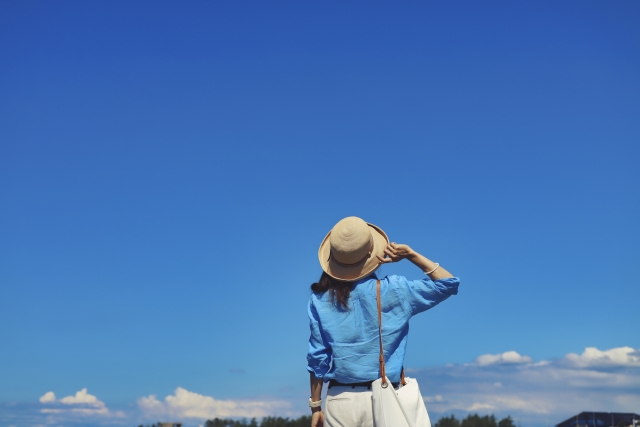 青空を見る女性の写真